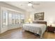 Bright main bedroom with wood floors, shuttered windows, a ceiling fan, and a landscape painting at 16100 W Galleria Ln, Surprise, AZ 85374