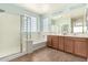 Well-lit bathroom featuring a glass shower, separate soaking tub, and double sink vanity at 17975 W Agave Rd, Goodyear, AZ 85338