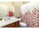 Bathroom vanity with sink and a floral shower curtain over the bathtub and toilet at 17975 W Agave Rd, Goodyear, AZ 85338