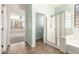 Clean bathroom with glass-enclosed shower, tile flooring, and a doorway leading to another room at 17975 W Agave Rd, Goodyear, AZ 85338