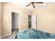 Bedroom view featuring plush carpet, a ceiling fan, and white doors to an adjacent room at 17975 W Agave Rd, Goodyear, AZ 85338