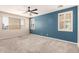 Spacious bedroom featuring a stylish accent wall, two bright windows, and neutral carpet at 17975 W Agave Rd, Goodyear, AZ 85338