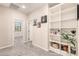 Bright bedroom with custom built-in shelving, plush carpet, and a door leading to another room at 17975 W Agave Rd, Goodyear, AZ 85338