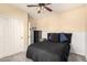 Bedroom features a ceiling fan, stylish bedding, and a closet with sliding doors at 17975 W Agave Rd, Goodyear, AZ 85338