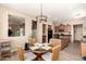 Dining area with a round glass-top table, wicker chairs, and a view into the kitchen and stairway at 17975 W Agave Rd, Goodyear, AZ 85338