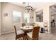 Dining room with a round table, wicker chairs, modern lighting, and wood-look tile flooring at 17975 W Agave Rd, Goodyear, AZ 85338