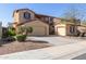 Beautiful stucco home with two garages, wrought iron gate, and low-maintenance landscaping at 17975 W Agave Rd, Goodyear, AZ 85338