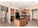 Spacious kitchen featuring an island, wood cabinets, stainless steel appliances, and wood-look tile flooring at 17975 W Agave Rd, Goodyear, AZ 85338