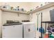 Laundry room featuring modern washer and dryer units and shelving for storage at 17975 W Agave Rd, Goodyear, AZ 85338