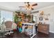 Sunlit craft room featuring dark hardwood floors, custom storage, and a chandelier fan for a creative space at 18504 W Maui Ln, Surprise, AZ 85388