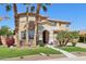 Charming two-story home showcasing lush landscaping, including stately palm trees and healthy green grass at 18504 W Maui Ln, Surprise, AZ 85388