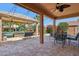 Outdoor patio features travertine tile flooring, ample seating, string lights, and a view of the pool at 18504 W Maui Ln, Surprise, AZ 85388