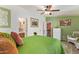 Cozy bedroom featuring a green bedspread, decorative pillows, ceiling fan and a small seating area at 201 S Greenfield Rd # 65, Mesa, AZ 85206