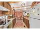 Bright kitchen featuring wooden beams, countertops, white appliances, and a red and white patterned rug at 201 S Greenfield Rd # 65, Mesa, AZ 85206