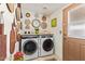 Laundry room featuring modern washer and dryer, decorative wall hangings, and an exterior door at 201 S Greenfield Rd # 65, Mesa, AZ 85206