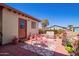 Charming patio featuring red accents, outdoor seating, decorative plants, and manicured landscaping at 201 S Greenfield Rd # 65, Mesa, AZ 85206