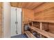 Wooden sauna featuring bench seating, a traditional heater, and a mounted shower head at 201 S Greenfield Rd # 65, Mesa, AZ 85206