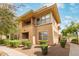 Inviting exterior showcases a two-story condo with a balcony, manicured bushes, and a landscaped yard at 20100 N 78Th Pl # 1013, Scottsdale, AZ 85255