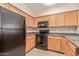 Well-lit kitchen features matching black appliances and plenty of wood cabinets for storage at 20100 N 78Th Pl # 1013, Scottsdale, AZ 85255