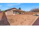 View of the dirt backyard featuring a patio, a porch swing, and block privacy walls at 21655 N Davis Way, Maricopa, AZ 85138