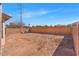 Spacious dirt backyard is fenced with privacy walls, offering a blank canvas for landscaping at 21655 N Davis Way, Maricopa, AZ 85138