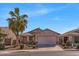 Charming single-story home with desert landscaping, a palm tree, and a two-car garage in a sunny neighborhood at 21655 N Davis Way, Maricopa, AZ 85138