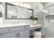 Modern bathroom featuring gray vanity, framed mirror, quartz countertop, and walk-in shower with glass door at 220 W Wood Dr, Chandler, AZ 85248