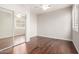 Bedroom featuring hardwood floors, mirrored closet doors, two windows and a ceiling fan at 220 W Wood Dr, Chandler, AZ 85248