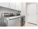 Laundry room featuring modern front-loading washer and dryer and upper cabinets at 220 W Wood Dr, Chandler, AZ 85248