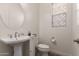 Elegant powder room with a pedestal sink and decorative window coverings at 23133 N 73Rd Pl, Scottsdale, AZ 85255