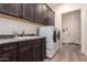 Bright laundry room with modern washer and dryer, ample cabinet space, sink, and tile flooring at 23133 N 73Rd Pl, Scottsdale, AZ 85255