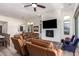 Comfortable living room with leather furniture, fireplace, and large windows for natural light and backyard view at 23133 N 73Rd Pl, Scottsdale, AZ 85255