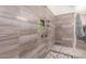 Modern walk-in shower featuring stone-look tile and mosaic flooring at 23133 N 73Rd Pl, Scottsdale, AZ 85255