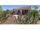 Lush backyard featuring desert landscaping, a covered patio, and vibrant cacti adding a touch of natural beauty at 26288 W Horsham Ct, Buckeye, AZ 85396