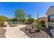 Private backyard featuring desert landscaping, a built-in bench with colorful cushions, and a cozy fire pit area at 26288 W Horsham Ct, Buckeye, AZ 85396