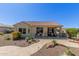 Stunning backyard showcasing desert landscaping, a covered patio, and a winding stone pathway for scenic strolls at 26288 W Horsham Ct, Buckeye, AZ 85396