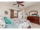 Bedroom with barn door to the bathroom, cherry wood furniture, and large windows at 26288 W Horsham Ct, Buckeye, AZ 85396