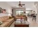 Inviting living room with neutral tones, a ceiling fan, and views to the back yard and dining area at 26288 W Horsham Ct, Buckeye, AZ 85396