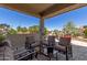 Inviting covered patio featuring comfortable seating and a stylish glass-topped coffee table with beautiful desert views at 26288 W Horsham Ct, Buckeye, AZ 85396