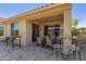 Charming covered patio with stone flooring offering ample seating and a convenient bar area for outdoor entertaining at 26288 W Horsham Ct, Buckeye, AZ 85396