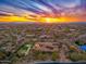 Long aerial view of estate showcasing tile roof, pool, putting green, and basketball court at sunset at 27632 N 68Th Pl, Scottsdale, AZ 85266