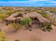 Aerial view of a luxurious home with circular driveway, red tile roof, and desert landscaping at 27632 N 68Th Pl, Scottsdale, AZ 85266