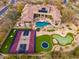 Backyard aerial view, displaying pool with rock features, putting green, trampoline, and basketball court at 27632 N 68Th Pl, Scottsdale, AZ 85266