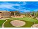 Expansive backyard features a sand trap and putting green for golf enthusiasts, surrounded by desert landscaping at 27632 N 68Th Pl, Scottsdale, AZ 85266