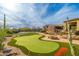 Resort-style backyard boasts a putting green, basketball court, climbing wall, and lush landscaping, ideal for outdoor activities at 27632 N 68Th Pl, Scottsdale, AZ 85266