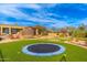 Beautiful backyard showcasing a putting green, rock feature, and trampoline, great for entertaining and relaxation at 27632 N 68Th Pl, Scottsdale, AZ 85266