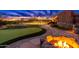 Entertainer's backyard featuring a putting green, tennis court, trampoline, and outdoor fire pit at 27632 N 68Th Pl, Scottsdale, AZ 85266