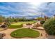 Desert backyard features a fire pit, putting green, and natural landscaping, creating a serene outdoor space at 27632 N 68Th Pl, Scottsdale, AZ 85266