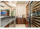 Stylish bar area with granite countertops, custom cabinetry, and a built-in wine refrigerator at 27632 N 68Th Pl, Scottsdale, AZ 85266