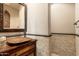 Charming powder room featuring a copper vessel sink and decorative tile accent wall at 27632 N 68Th Pl, Scottsdale, AZ 85266